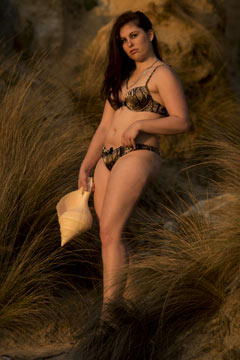 attractive brunette in plus-sized lingerie modelling on ocean foreshore