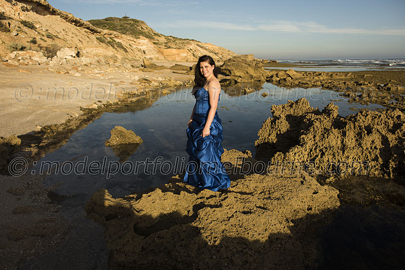 modelling a formal gown on the edge of the sea